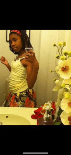 a young girl is taking a selfie in front of a mirror