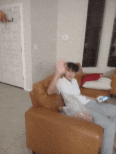 a blurry picture of a person sitting on a couch with their hand up