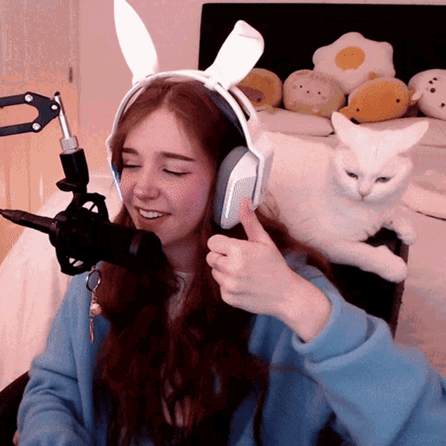 a girl wearing bunny ears giving a thumbs up