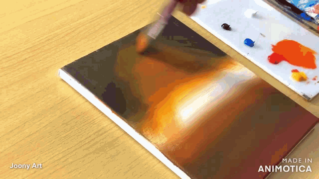 a painting is being painted on a wooden table and the painting is made by joony art