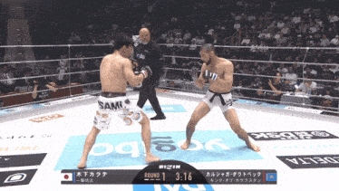 two men are fighting in a boxing ring with a scoreboard that says round 1 at 3:16