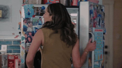 a woman standing in front of a refrigerator with a box of nestle cereal on the counter