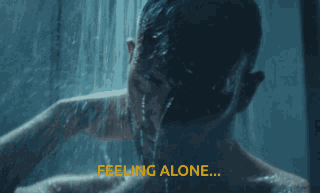 a man is taking a shower and the words feeling alone are above him