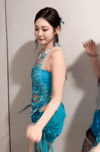 a woman in a blue dress is standing next to another woman
