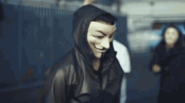 a man wearing a hooded jacket and a white mask