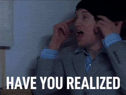 a man wearing a suit and a beanie says " have you realized "