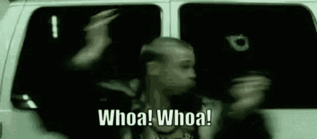 a man is standing in a van with his hands in the air and says `` whoa whoa '' .
