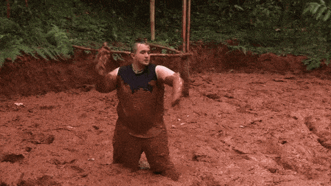 a man is kneeling in a muddy field