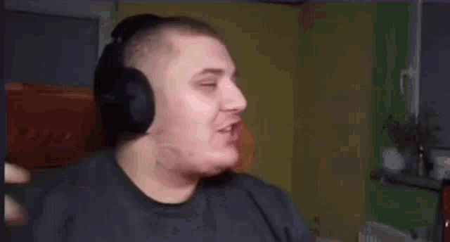 a man wearing headphones is making a funny face while sitting in a chair .