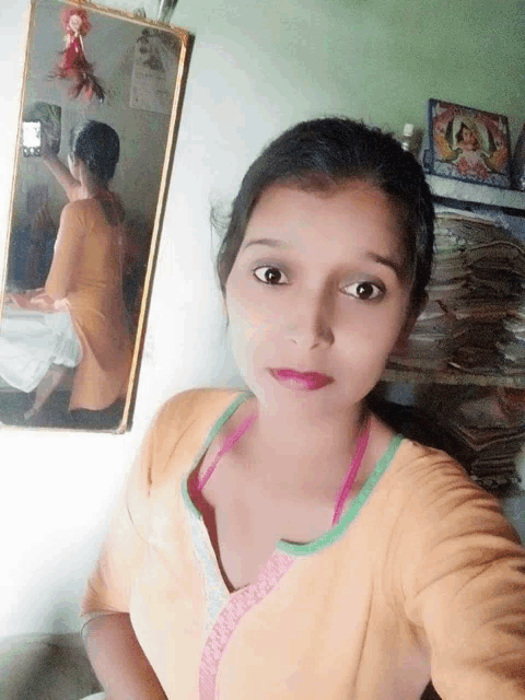 a woman taking a picture of herself in a mirror