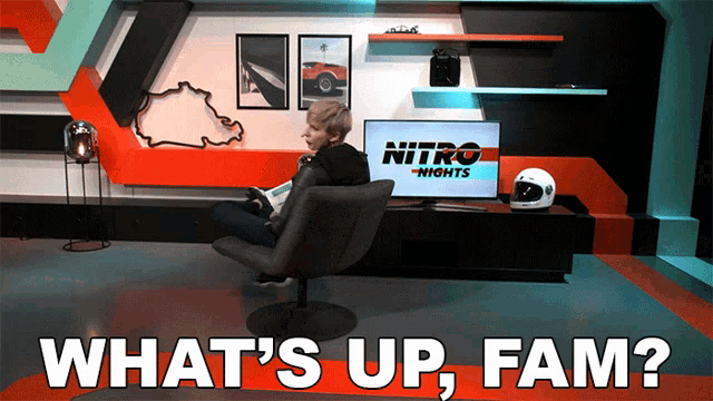 a man sits in a chair in front of a tv that says nitro nights on it