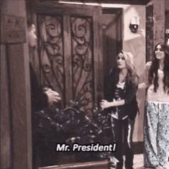 a group of people are standing in front of a door and one of them is saying mr. president .