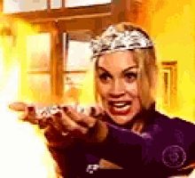 a woman wearing a tiara is pointing at something .
