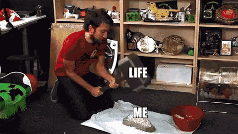 a man in a red shirt is kneeling down with a hammer in front of a shelf that says life on it