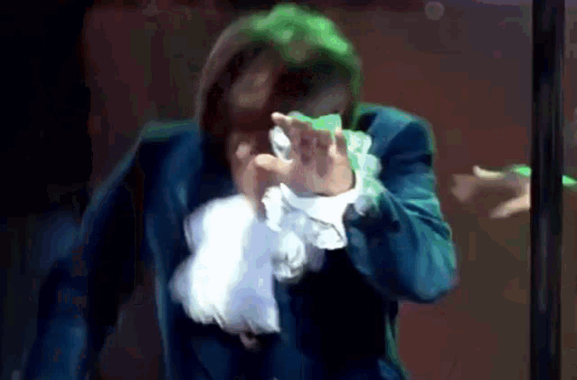 a man in a blue jacket and white collared shirt is covered in green slime