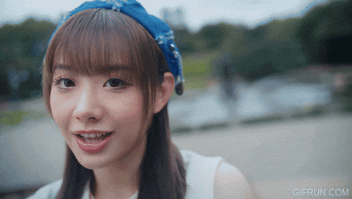 a girl wearing a blue headband looks at the camera with gifrun.com in the lower right corner