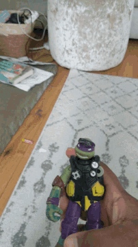 a person is holding a teenage mutant ninja turtles action figure