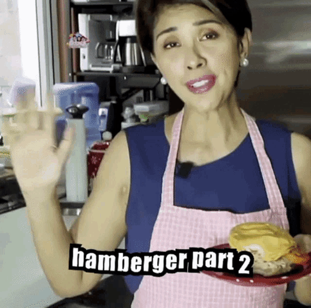 a woman in an apron is holding a plate with a hamburger on it and says hamburger part 2