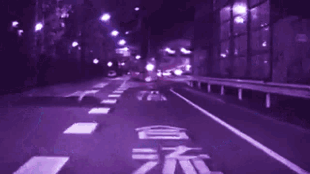 a blurry picture of a street at night with a purple background and a red white and blue square with the letter p on it