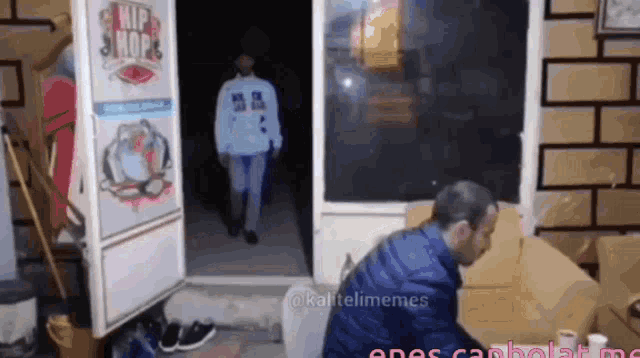 a man in a blue jacket stands in front of a hip hop shop