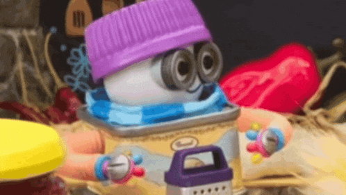 a cartoon character wearing a purple hat and scarf is sitting on a table .
