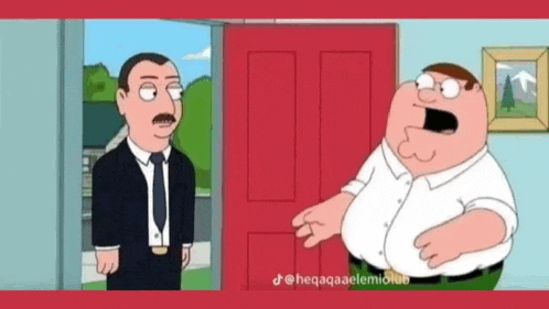 peter griffin is standing next to a man in a suit and tie .