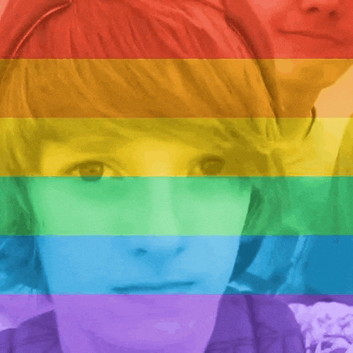 a person 's face is behind a rainbow colored background