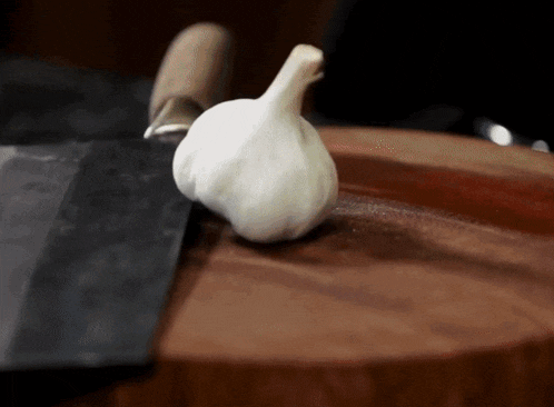 a person is cutting garlic on a cutting board