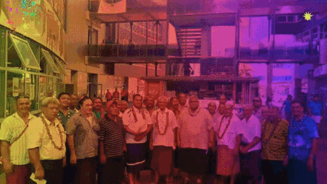 a group of people are posing for a photo in front of a building with a sign that says ' a ' on it