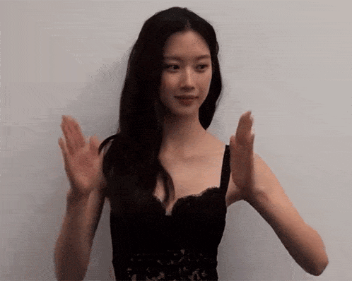 a woman in a black bra is clapping her hands .