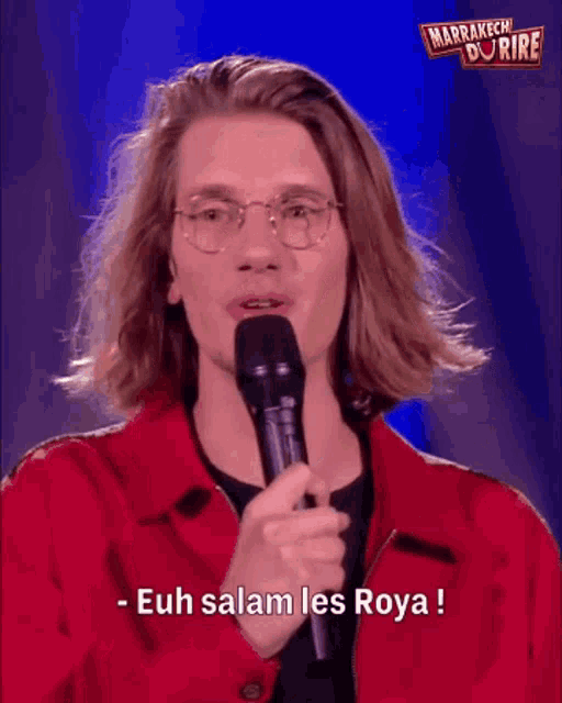a man speaking into a microphone with the words euh salam les roya written below him