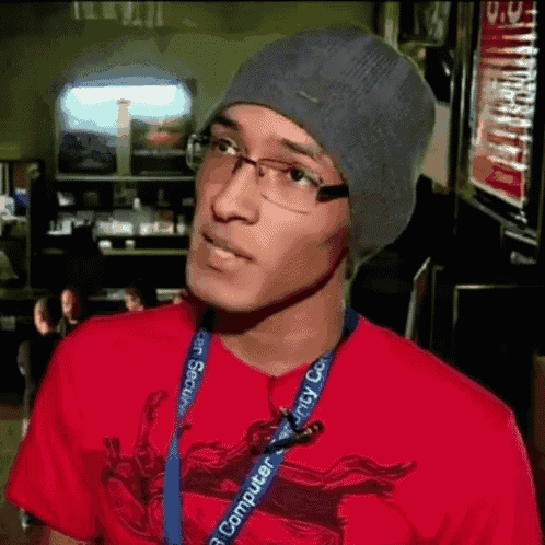 a man wearing glasses and a beanie is wearing a lanyard that says computer security