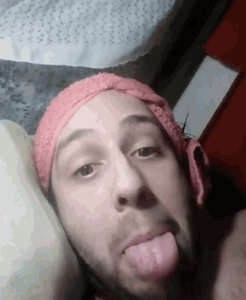 a man with a towel around his head is sticking his tongue out