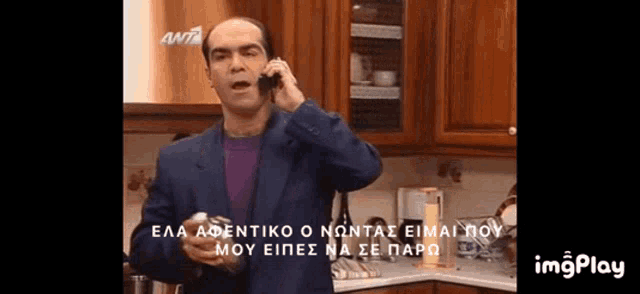 a man in a suit is talking on a cell phone in a kitchen .