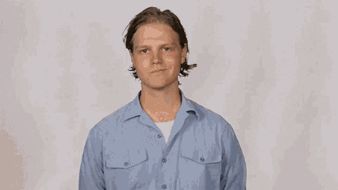 a man in a blue shirt is making a funny face .