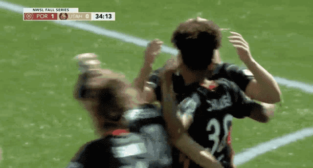 a soccer player wearing a number 32 jersey is hugging another player