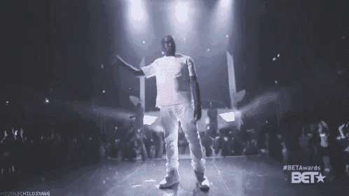 a man in a white shirt is standing on a stage in front of a crowd and the words beta awards on the bottom