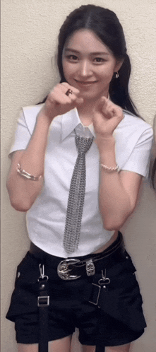 a woman wearing a white shirt and black shorts is smiling