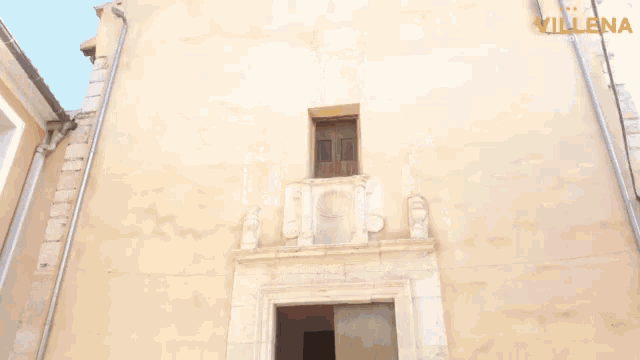 a group of people are standing outside of a building with the word villena on the bottom