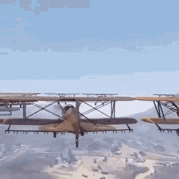 a small airplane is flying over a city with mountains in the background .