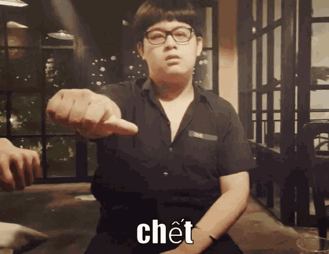a man wearing glasses and a black shirt is pointing at the camera with the word chet written on the bottom
