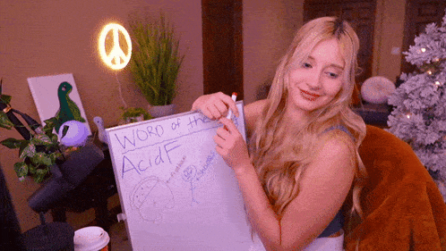 a woman is holding up a white board that says word of the acidf