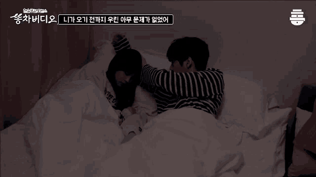 a man and a woman are laying on a bed with korean writing on the bottom right corner