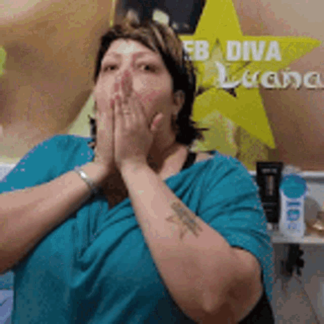 a woman is covering her mouth with her hands in front of a poster that says fb diva luana