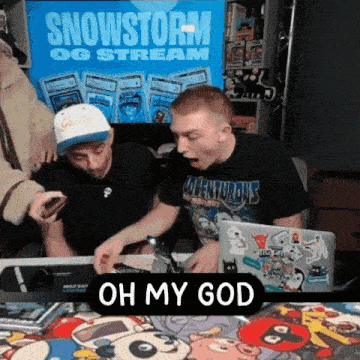 two men are sitting at a table with a sign that says snowstorm og stream