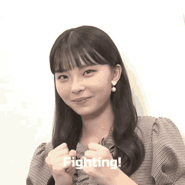 a girl is making a fist and the word fighting is visible