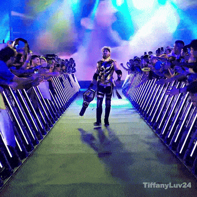a wrestler is walking through a tunnel with a tiffanyluv24 logo on the bottom