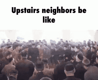 a large group of people are standing in a room .
