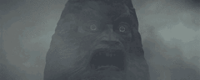 a statue of a man with a beard is covered in fog and looks scary .