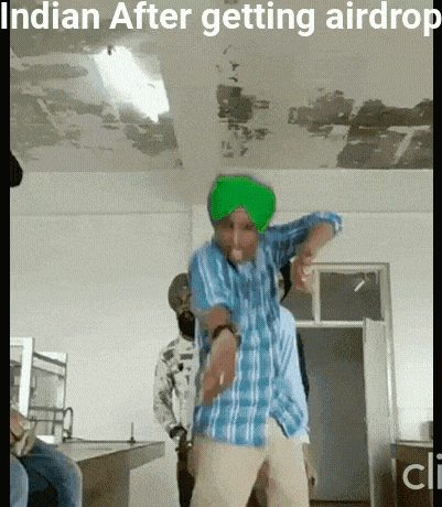 a man with a green turban is dancing in a room with other people .